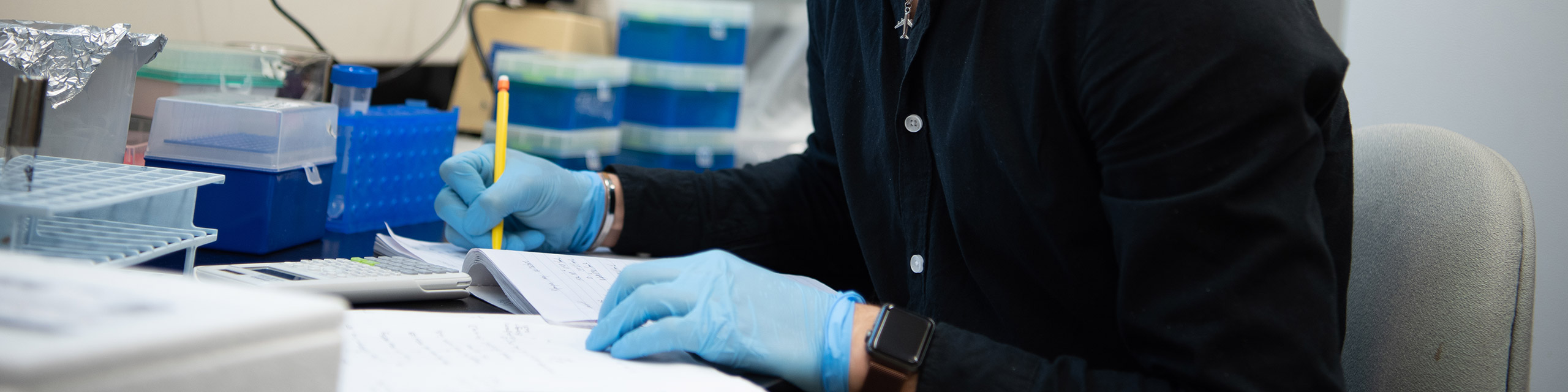 A student in a lab taking notes