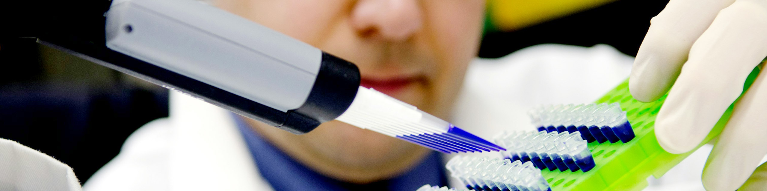 A scientist in a lab conducting research in molecular and cellular biology.