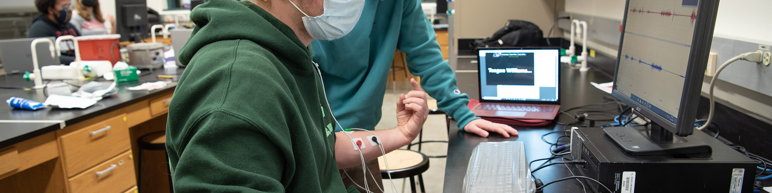 Group of students studying physiology in a lab setting.